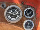 a close up of a dashboard with gauges and a steering wheel