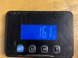 a digital clock that is on the table next to a cell phone
