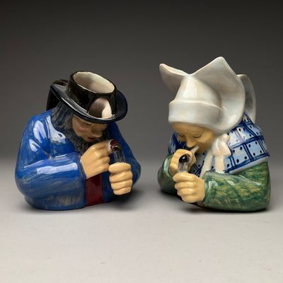 deux figurines représentant deux personnes portant chacune un chapeau