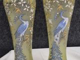 two vases with peacocks painted on them sitting on a table