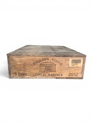 une vieille boîte en bois avec une étiquette posée sur une surface blanche