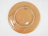 a brown plate with a ring on it on a white table