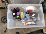 a plastic box filled with assorted items on the ground