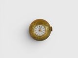 an old gold pocket watch with a white face on a white surface