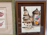trois tableaux encadrés représentant différents types d'œuvres d'art, posés sur une table