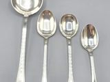 five silver spoons and a spoon with a spoon on top of them