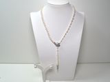 un collier et des boucles d'oreilles posés sur un mannequin, sur une surface blanche