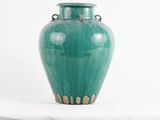 a large green vase sitting on a white surface