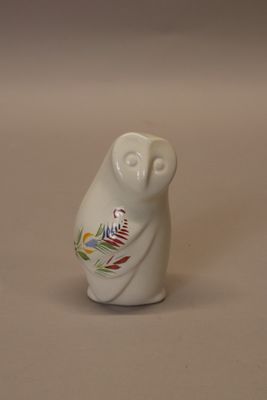 a small white owl figurine sitting on a table