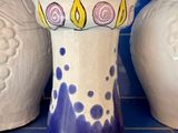 trois vases posés sur un sol en carrelage bleu