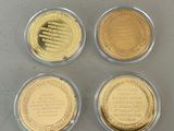 four gold coins with different designs on them sitting on a table