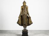 a bronze statue of a buddha standing on a pedestal