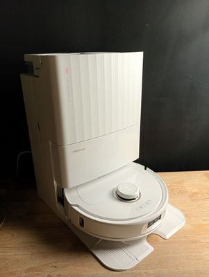 une cuvette de WC blanche posée sur une table en bois