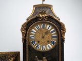 a clock with a statue on top of it next to a box