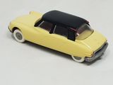 a yellow toy car with a black top on a white surface