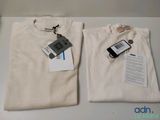 deux t-shirts et un téléphone portable posés sur une table
