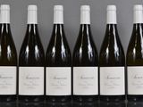 six bouteilles de vin sont alignées sur une table
