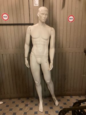 a white mannequin in a room with a checkered floor