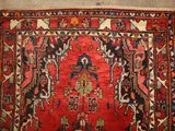 a red rug with a design on it on a floor