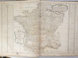 an old book with a map of france on it sitting on a table