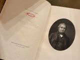 an open book with a picture of a man in a suit sitting on top of a table