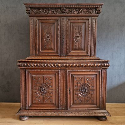 une vieille armoire en bois avec des sculptures et des gravures sur les portes