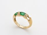 a gold ring with emerald stones and diamonds