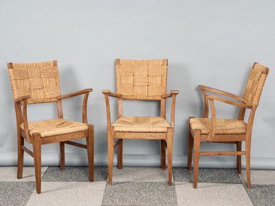trois chaises en bois placées les unes à côté des autres sur un sol à carreaux