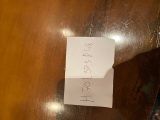 a piece of paper on a wooden table with writing on it