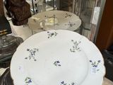 a person holding a plate with purple flowers on it