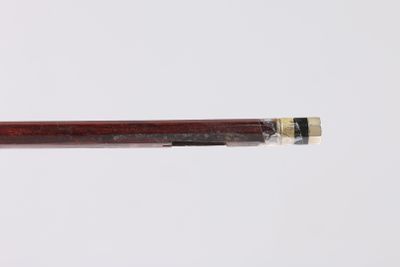 un gros plan d'un stylo à manche en bois posé sur une surface blanche