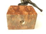 statue of a woman sitting on a block with a bird in her hand