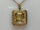 an image of a necklace with a yellow stone on a white background