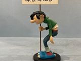 figurine of a man holding a sign that says mon aux cadances infernales
