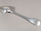 une cuillère en argent avec un manche de cuillère sur une table