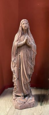 a statue of a woman holding a rosary on a table