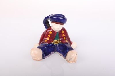 a small figurine of a man sitting on the ground