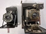 two old cameras sitting next to each other on a table
