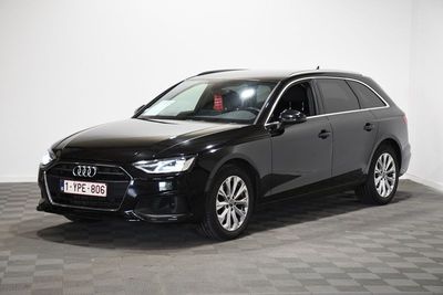 Un SUV Audi noir est garé dans une pièce blanche