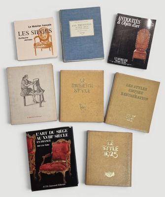 Plusieurs livres sont alignés sur une table près d'une chaise