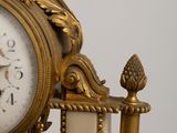 a clock that is sitting on a stand with a candle