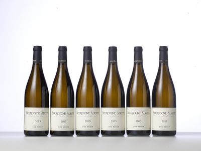 six bottles of wine lined up in a row on a table