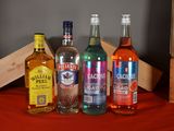 several bottles of alcohol are lined up on a red table