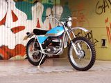 a blue motorcycle parked in front of a graffiti covered wall