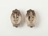 two silver spoons with a face on them sitting next to each other
