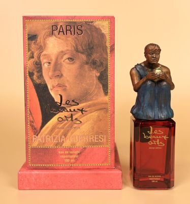 a small figurine of a woman next to a box of perfume