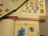 two open books on a table with stamps on them