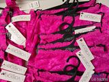several pairs of scissors and tags on a pink dress