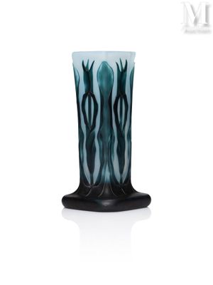 un vase noir et bleu posé sur une table blanche