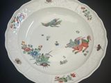 une assiette blanche ornée d'un motif représentant un oiseau et des fleurs